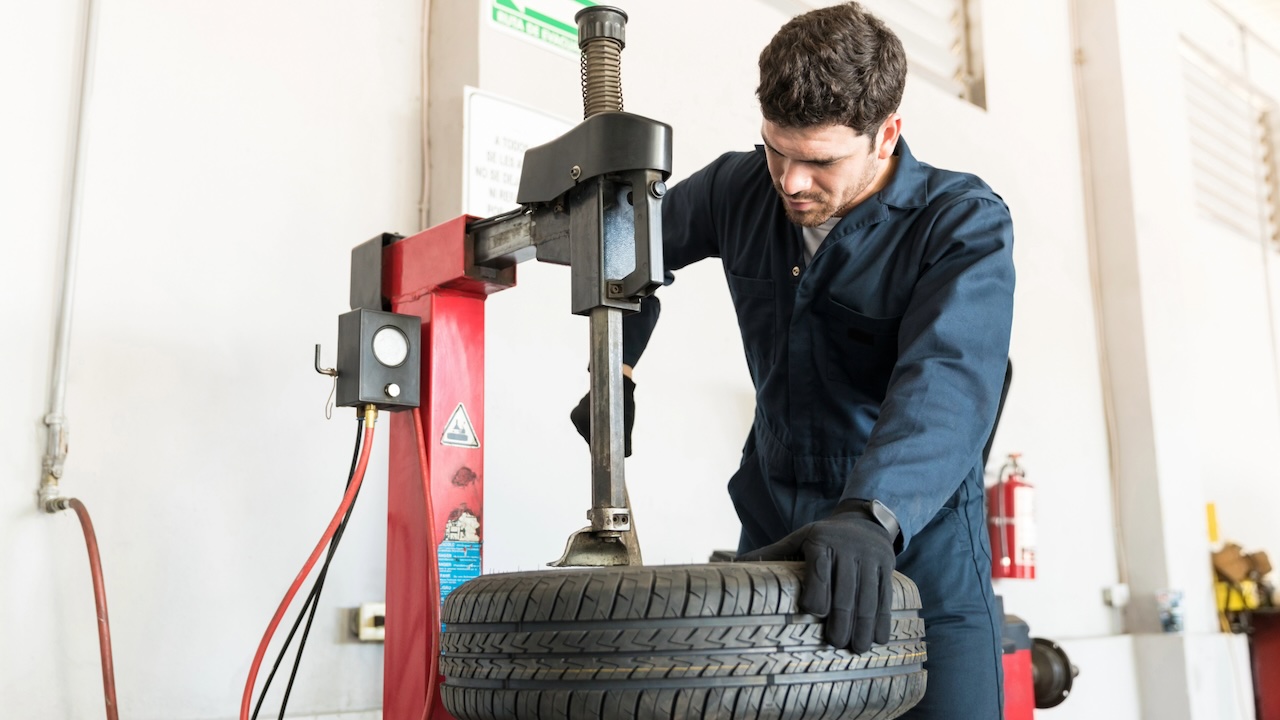 Tire changer - Repairman with tire